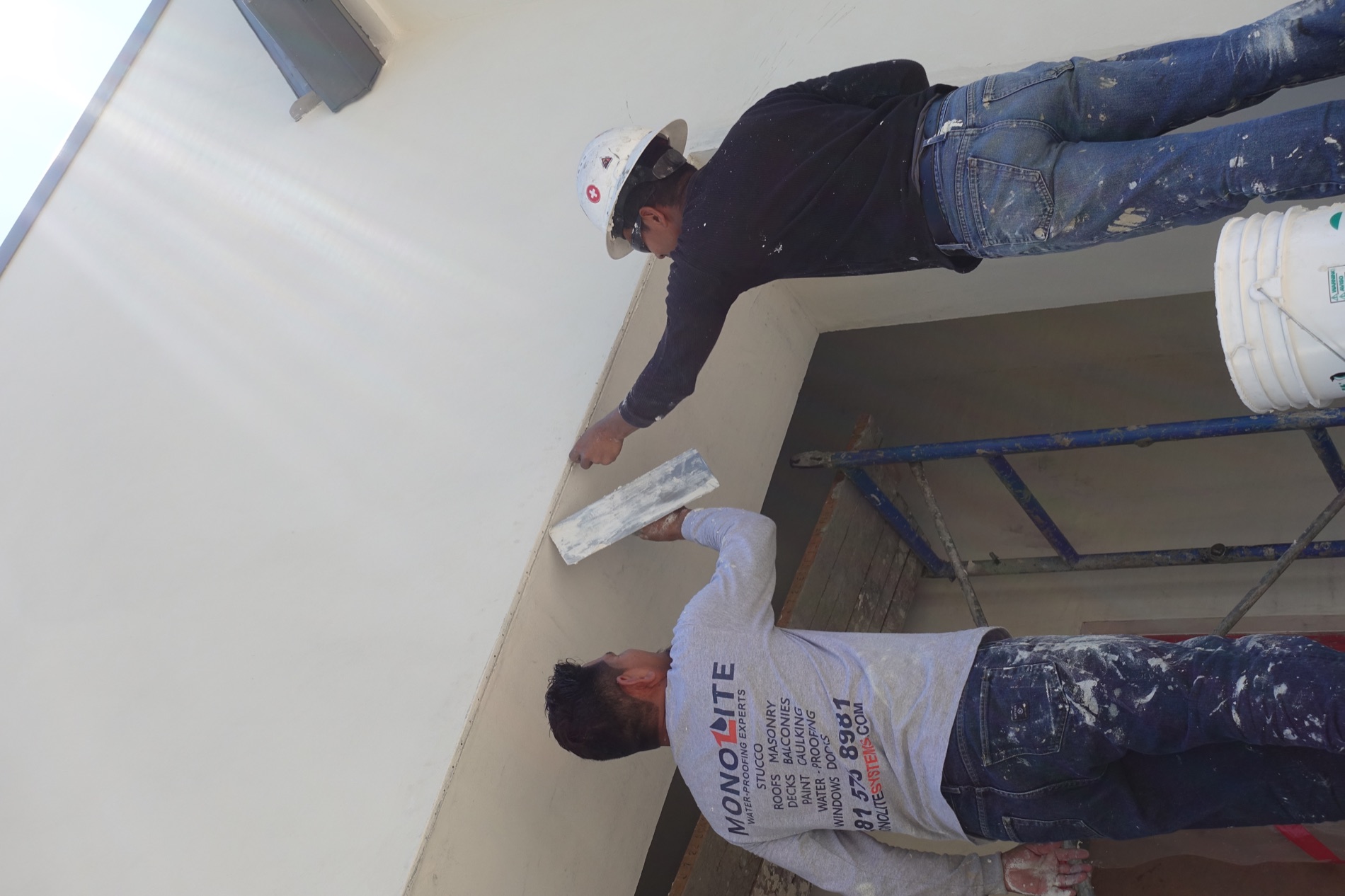 Monolite craftsmen applying stucco to a custom home exterior